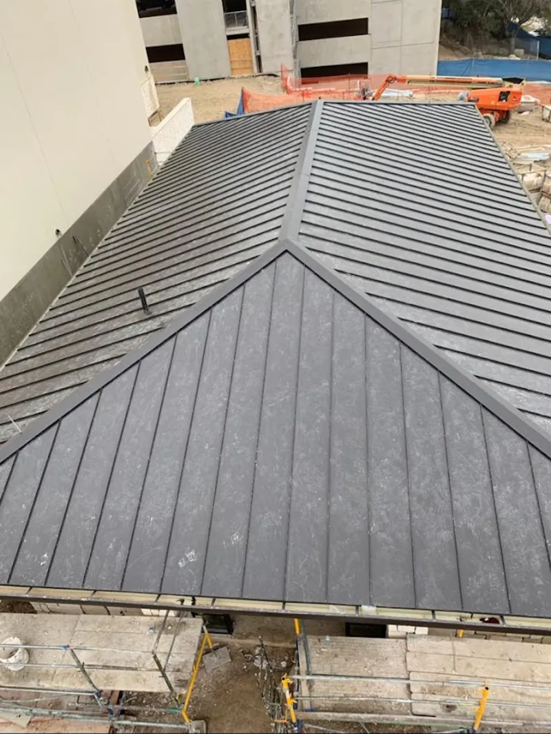 Commercial metal roof construction with crane equipment in Fife